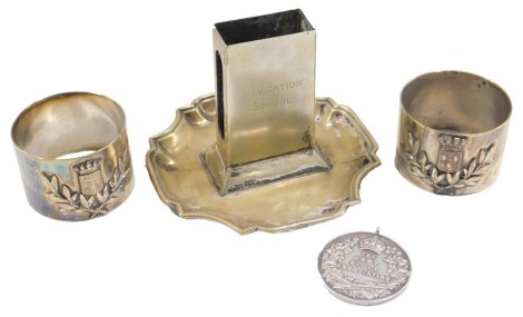 An Army Rifle Association medal, awarded to a Lance Corporal G Stennet at the Company Match 1921, and a match case engraved Navigation School Presented by Lieutenant Commander JH Drummond RN 1921, and two silver plated napkin rings. (4)