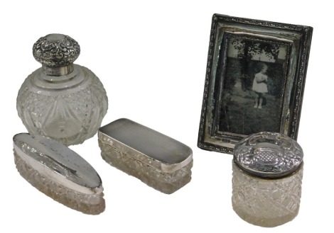 A quantity of silver and silver mounted items, to include rectangular photograph frame, scent bottle, three jars and covers.