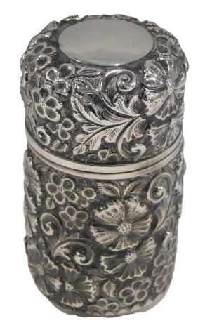 An Edward VII silver cased scent bottle, embossed with an all over design of flowers and scrolls, the hinged lid with vacant circular plaque or cartouche enclosing a scent bottle with glass stopper, London 1915, 8cm high.