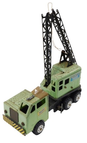 A mid century green tinplate construction lorry, with crane.