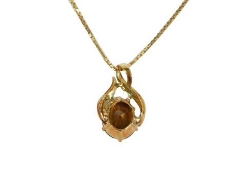 A 20thC topaz pendant and chain, the oval cut topaz in claw setting, 11mm x 9mm x 6.8mm, 5.02ct, in a hollow yellow metal frame, unmarked, believed to be 18ct gold, on a box link neck chain, yellow metal stamped 585, the pendant 1.5cm high, the chain 44cm