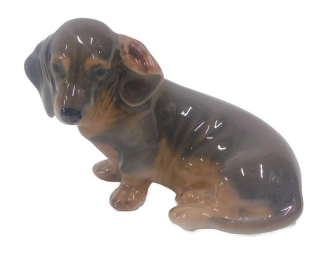 A Royal Copenhagen porcelain model of a seated Dachshund puppy, number 140, 12cm long.