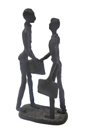 A bronzed cast iron sculpture of two figures shaking hands, 23cm high.