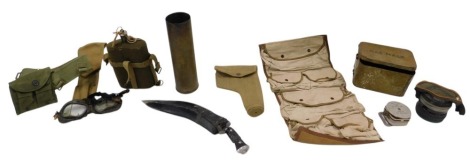 A collection of militaria, to include a pair of goggles, gas mask, brass shell case, kukri.