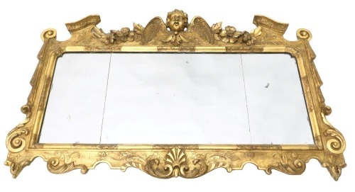 An 18thC gilt wood and gesso over mantel mirror, the crest decorated with a stylised angel flanked by flowers and leaves, above three mirror plates, flanked by drapes and scrolls, 77cm high, 117cm wide.