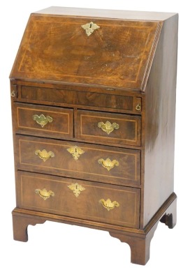 A walnut bureau in mid 18thC style, the fall enclosing a fitted interior, with well above two short and two long drawers, each with engraved brass bat shaped handles, and lozenge shaped escutcheons, on bracket feet, 61cm wide.