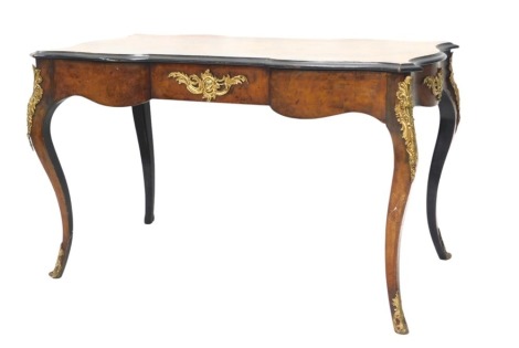 A Continental walnut and ebonised library table or bureau plat, the quarter veneered top above a shaped frieze with gilt metal mounts, on cabriole legs, 74cm high, 120cm wide.