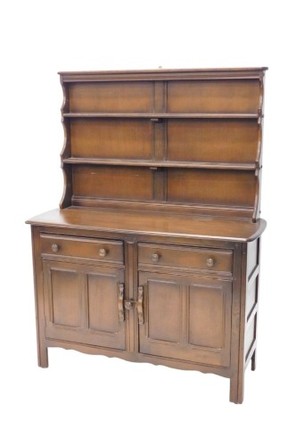 An Ercol dresser, the raised back with two plate shelves, the elm base with an arrangement of two drawers and two doors, on styles, 117cm wide.