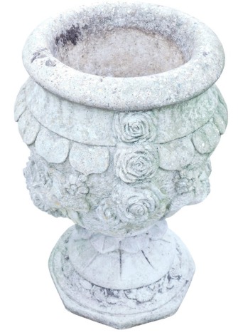 A composition stone garden urn, decorated with rose heads and other floral motifs, on a circular floral carved base, 64cm high, together with a further planter.