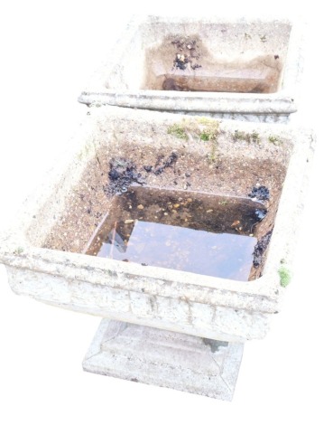 A pair of square composition garden planters, each of square tapering form, carved with floral motifs, on a stepped base, 42cm high.