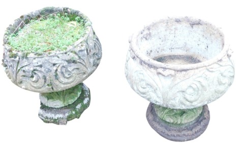 A pair of composition stone garden planters, each of cylindrical form, with scroll carved decoration, on pedestal base, 50cm high, 44cm diameter.