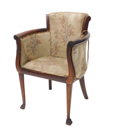 A late 19th/early 20thC mahogany tub chair, with an upholstered padded back, sides and seat, the frame with bell flower carved arm supports, on turned tapering legs, with paw feet.