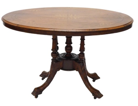 A Victorian walnut loo table, the oval tilt top on turned supports, with leaf carved splayed legs, 112cm wide.