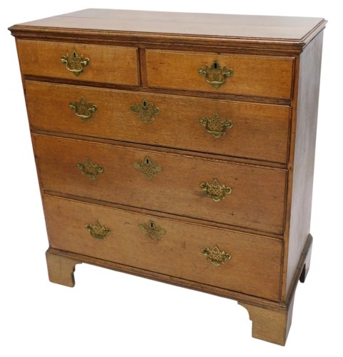 A George III oak chest of drawers, top with a moulded edge with two short and three long drawers, with pierced brass handles, on bracket feet, 113cm high, 107cm wide, 52cm deep.