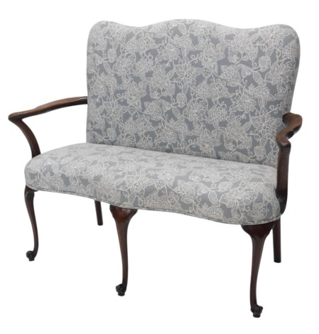 A mahogany sofa, in George III style, with a shaped back and seat upholstered in grey floral fabric, shepherd's crook shaped arms, on scroll carved cabriole legs, 119cm wide.