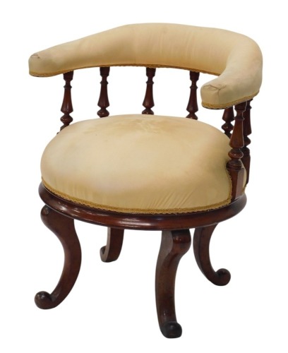 A Victorian mahogany tub shaped chair, with a padded back, spindle turned supports and a padded seat, on cabriole legs.