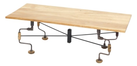 An unusual industrial coffee table, rectangular wooden top on metal sub frame mounted with woodworking braces, 40cm high, 118cm wide.