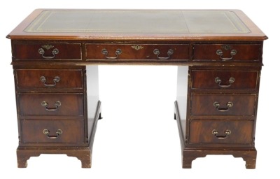 A mahogany pedestal desk, the rectangular top with a green leather inset above nine drawers, on bracket feet, 79cm high, 137cm wide, 77cm deep.