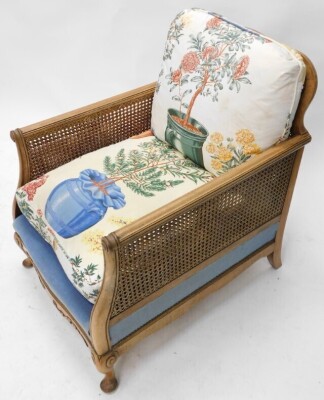 An early 20thC walnut bergere chair, with a caned back and sides, padded seat, on cabriole legs with pad feet. - 2