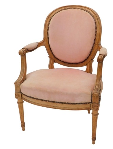 A late 19th/early 20thC French walnut open armchair, with a padded back, armrest and seat, with reeded arm supports, on turned and fluted legs.