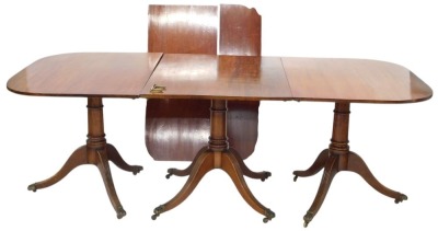 Withdrawn pre-sale. A 19thC mahogany three pillar dining table, the rectangular top with rounded corners, on a turned column and reeded tripod base with brass paw castors, two loose leaves and a set of brass clips, 76cm high, 304cm long, 108cm wide.