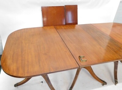 Withdrawn pre-sale. A 19thC mahogany three pillar dining table, the rectangular top with rounded corners, on a turned column and reeded tripod base with brass paw castors, two loose leaves and a set of brass clips, 76cm high, 304cm long, 108cm wide. - 2