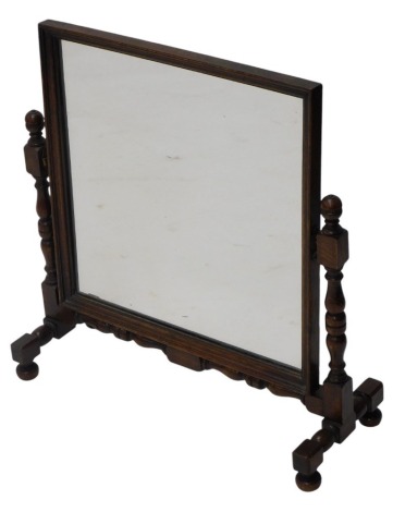 An oak dressing table mirror, the rectangular plate on turned supports, with bun feet, 66cm wide.