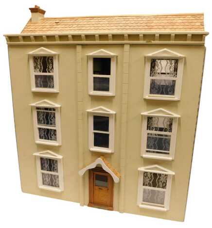 A 20thC three storey doll's house, painted cream, 88cm high.