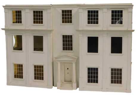 A 20thC three storey doll's house, in Regency style, painted white, 82cm high.