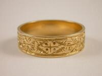 An 18ct gold wedding band with embossed design