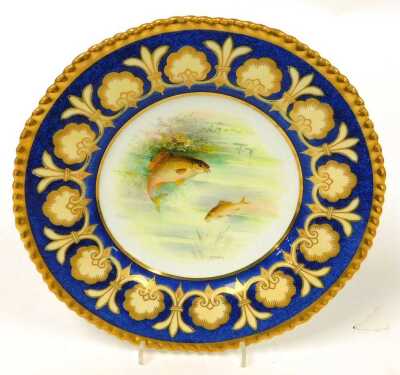 A pair of early 20thC Wedgwood porcelain plates, painted by A Holland, with bream, and carp, within a powder blue and gilt floral border, pattern number W1947, painted and printed marks, 23cm wide. - 2