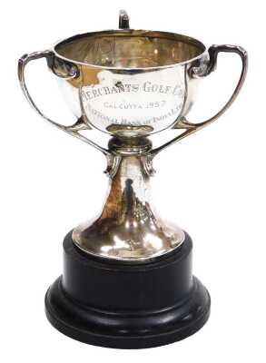 A 20thC Indian colonial silver trophy, of triple handle form, engraved 'Merchants Golf Cup, Calcutta 1957, National Bank of India Ltd', verso winner's names, Hamilton & Co, Calcutta & New Delhi, 9.72oz, with an ebonised socle.