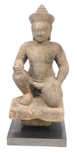 A Khmer sandstone figure of Varuna, in a seated door keeper pose as guardian of the west, possibly 10th/11thC, modelled wearing a sampot, with a jewelled headdress and collar, on a block fragment, raised on a black, rectangular base, 72cm high. Provenance