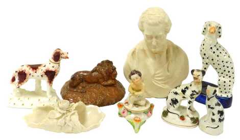 A group of English pottery and porcelain, including a Parian bust of Sir Robert Peel, Staffordshire brown glazed porcelain figure of a spaniel, in standing pose, further spaniels, a Staffordshire pottery seated Dalmatian, and a brown stoneware lid with a 