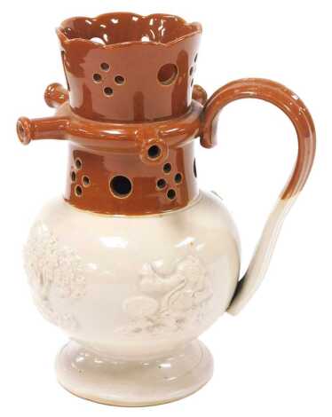 A 19thC Staffordshire two tone stoneware puzzle jug, sprig moulded with drinking figures, windmill and a tree, 20cm high. (AF)