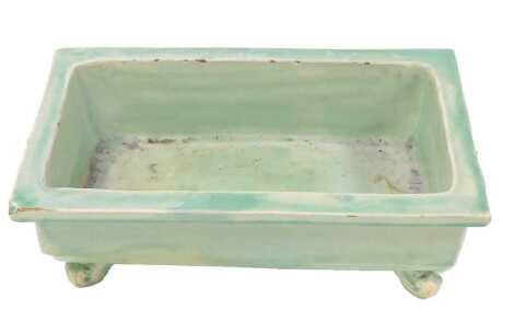 A late 19thC CH Brannam Barum green glazed pottery planter, of rectangular form, raised on scroll feet, incised mark, 35cm wide.