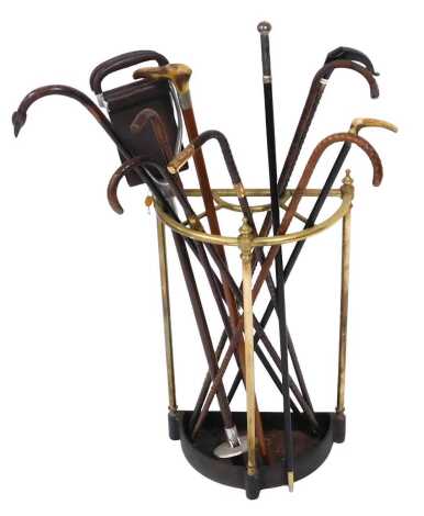 A Victorian brass and cast iron stick stand, of demi lune form, containing walking sticks and canes, and a shooting stick.