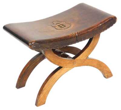 An early 20thC Heraldic x frame stool, with a curved seat, carved with a shield, with the capital letter B, 51cm wide.