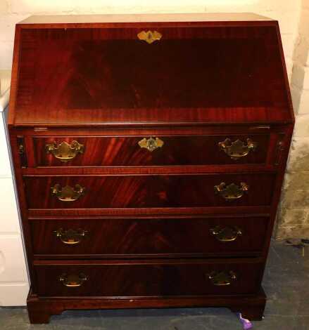 A teak four-drawer bureau, with brass escutcheon details, raised on bracket feet, internal drawers and cupboards, inset tooled leatherwork with fall, 74cm wide x 92cm high x 48cm deep.