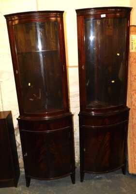 A pair of corner cabinets, semi-glazed, with low level locking cupboards, raised on tapered feet, solid shelves to upper glazed cabinet, 57cm wide x 179cm high x 36cm deep. (2)