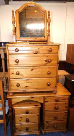 A pine bedroom suite, comprising a single pedestal dressing table, with table top pivoting mirror, 100cm wide x 75cm high x 45cm deep, a four drawer chest of drawers, and a three drawer bedside unit. (3)