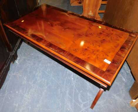 A low walnut coffee table, with x shaped legs, and turned central stretcher, 106cm long x 50cm high x 55cm deep. (AF)