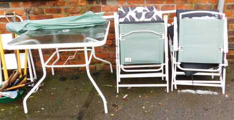 A garden set, comprising table, four folding chairs and a parasol.