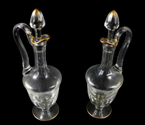 A pair of St Louis cut glass claret jugs, each with a gilt rim, and stoppers, 41cm high.