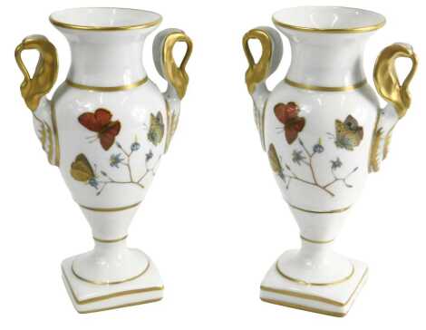 A pair of Paris porcelain two handled vases, each decorated with flowers and butterflies, on a square base, printed marks to underside, 20cm high.