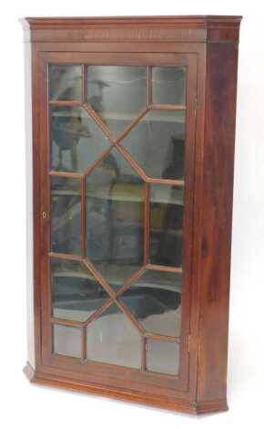 A George III mahogany corner wall cupboard, with an astragal glazed door, the interior with shaped shelves, 117cm high.