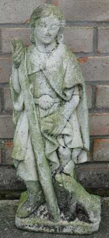 A carved stone figure of a man holding a staff beside a dog in Medieval style, 55cm high.