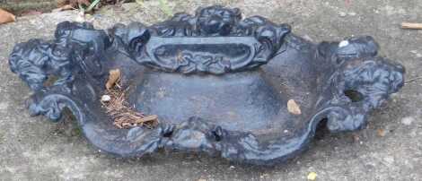 A 19thC cast iron boot scraper, decorated with lion masks.