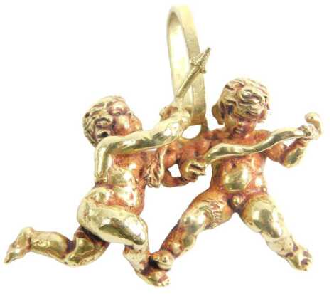 An 18ct gold pendant, formed as two cherubs with cupids and bows, 3cm wide, stamped 750, 17.9g. Upon initial inspection overall brown/red staining or possibly from polish but unclear, mainly to areas difficult to clean, no apparent damage.