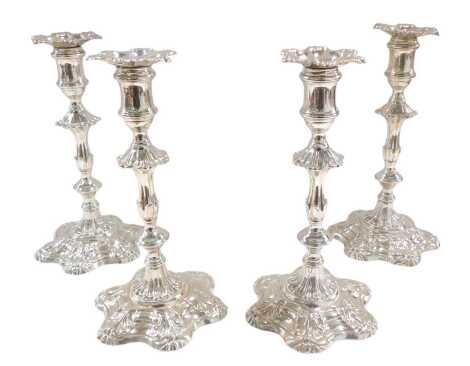 A set of four George III silver cast candlesticks by William Cafe, each with a shell cast sconce, a part scroll and turned column, and a shaped base embellished with shells, etc., London 1762, 83.72oz overall, 24cm high.